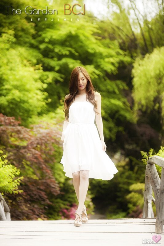 Woman in white dress on garden bridge