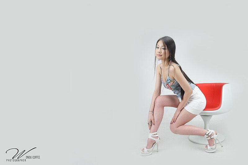 woman in white dress on red chair