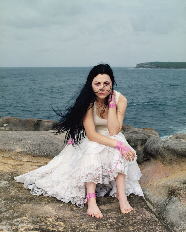 Woman in white dress on rocky shore