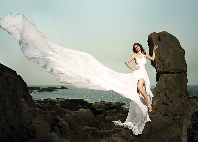Woman in white dress on rocky shore
