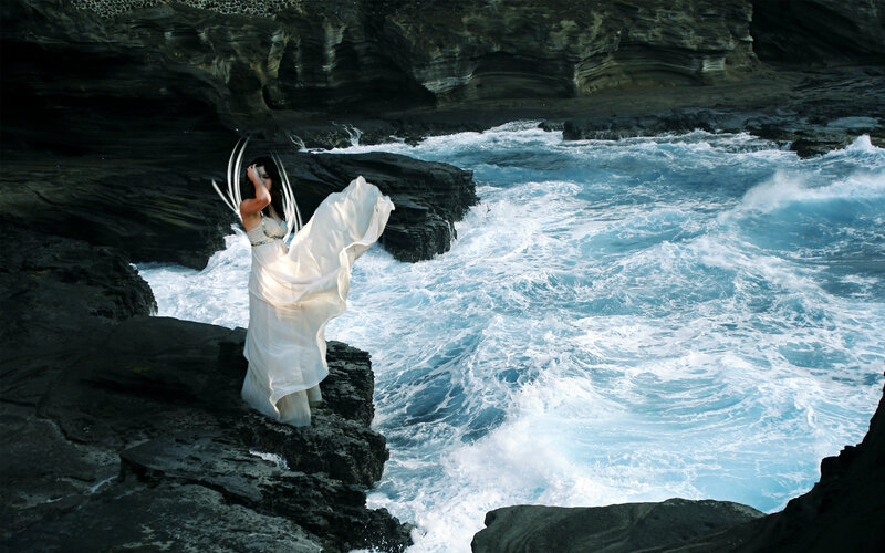 woman in white dress on rocky shore
