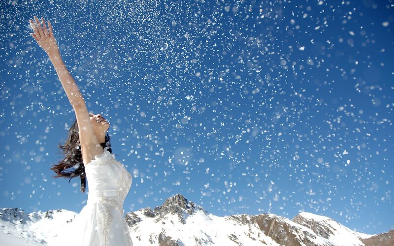 Woman in white dress on snowy mountain