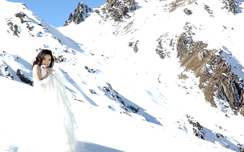 Woman in white dress on snowy mountain