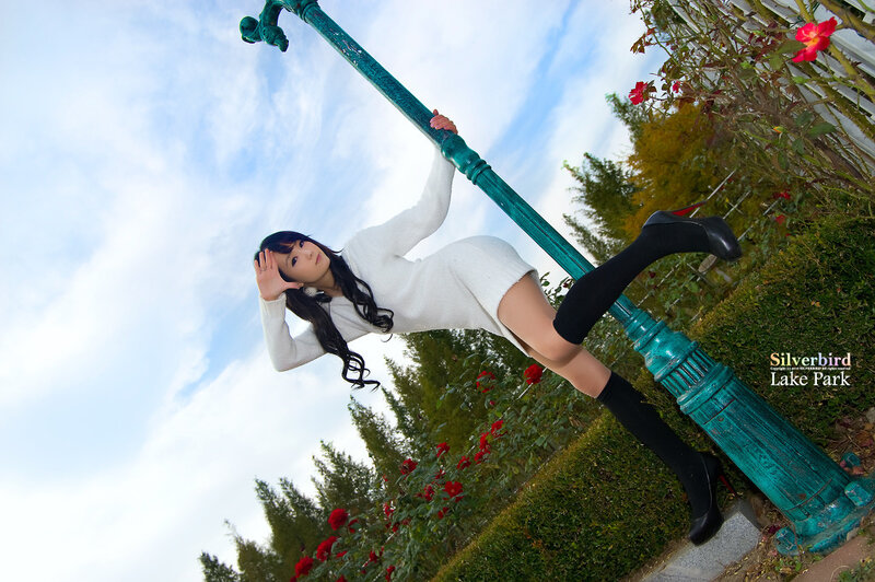Woman in white dress posing by lamp post