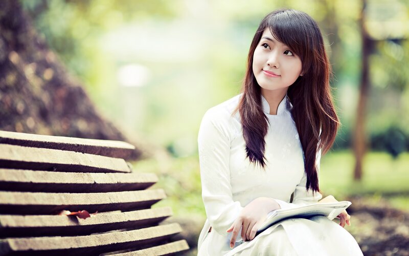 woman in white dress sitting on bench