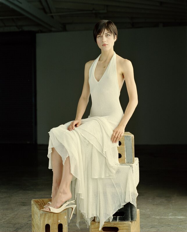 woman in white dress sitting on crates
