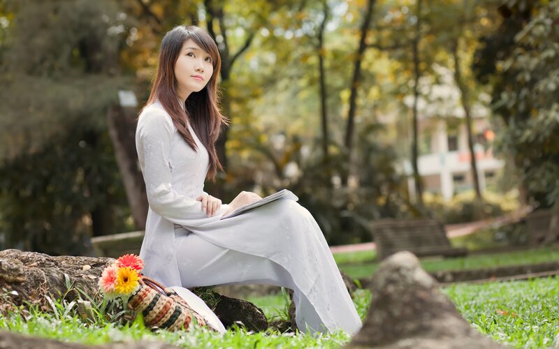 Woman in white dress sitting on grass
