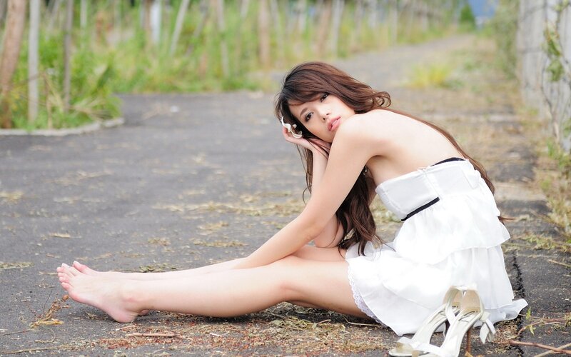 woman in white dress sitting on path