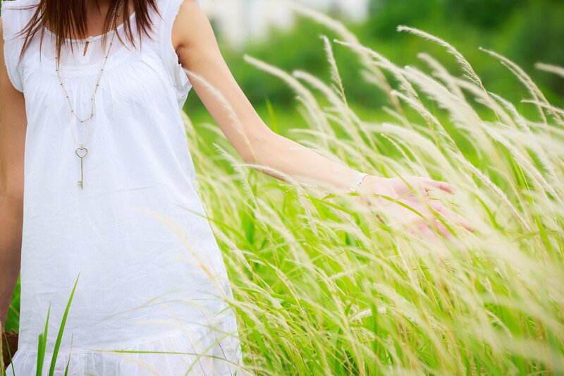 woman in white dress touching grass