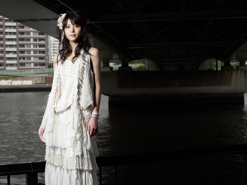 woman in white dress under bridge