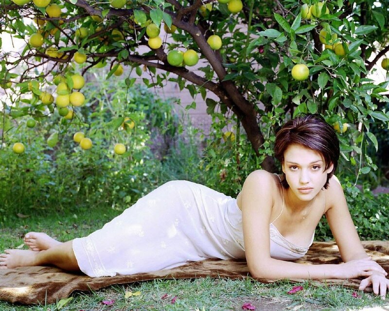 Woman in white dress under lemon tree