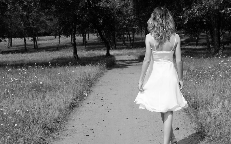 Woman in white dress walking on path