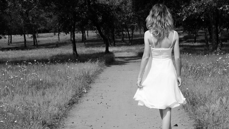 Woman in white dress walking path
