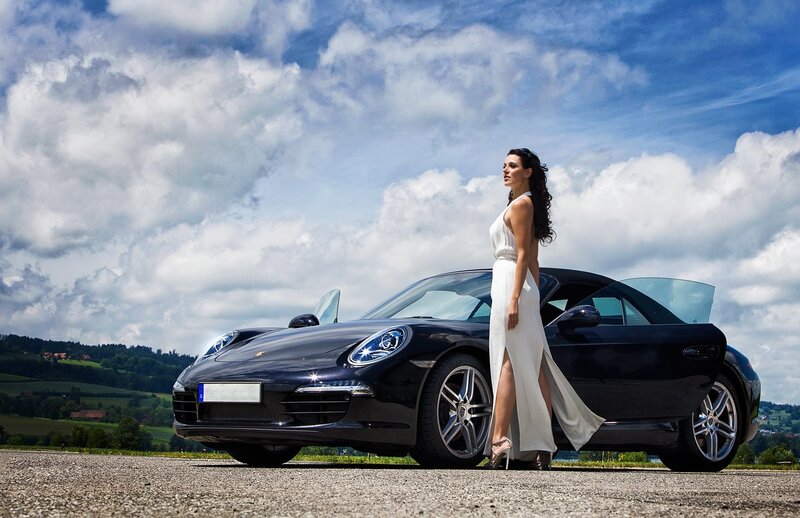 Woman in white dress with black car
