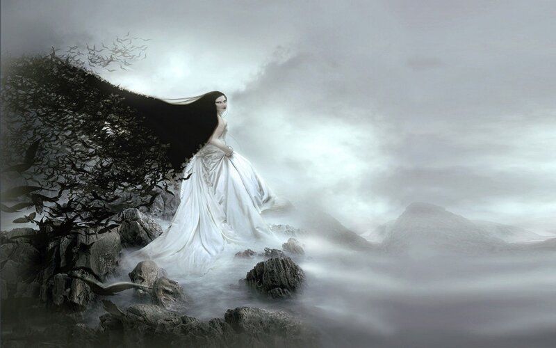 woman in white gown on rocky shore