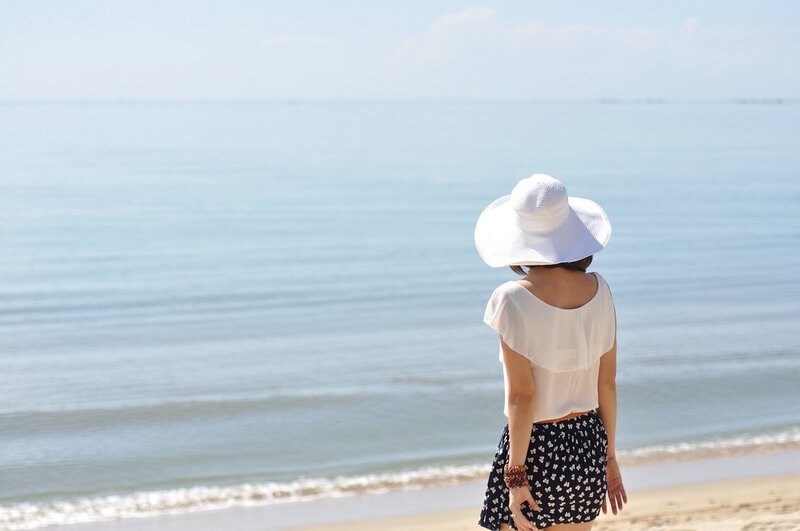 Woman in white hat at the beach