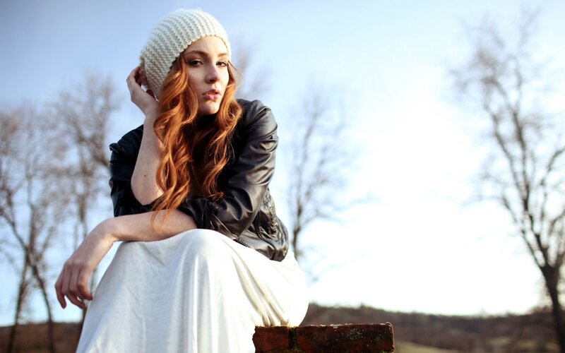 woman in white hat sitting outside