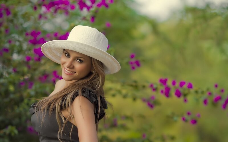 woman in white hat smiling