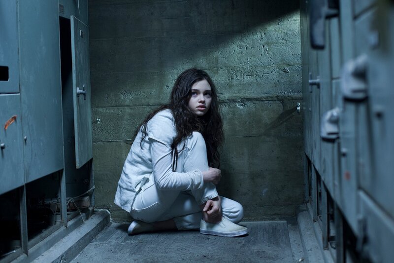 woman in white jumpsuit crouching