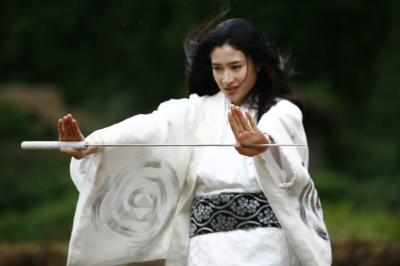 woman in white kimono holding sword