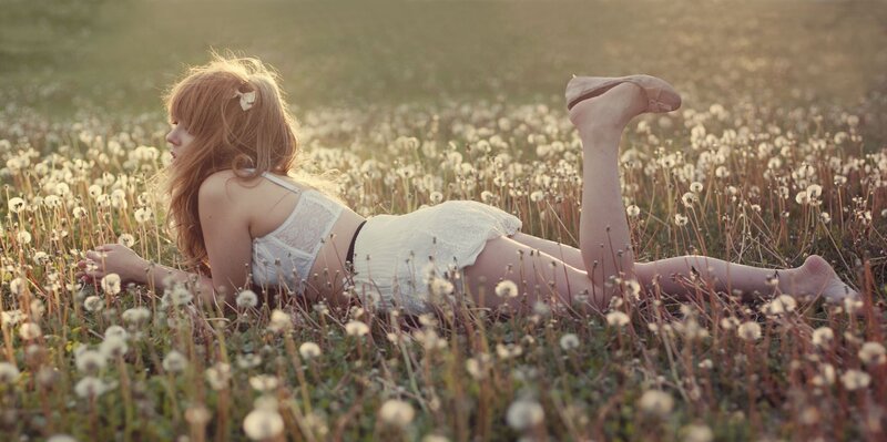 Woman in white lingerie on dandelion field
