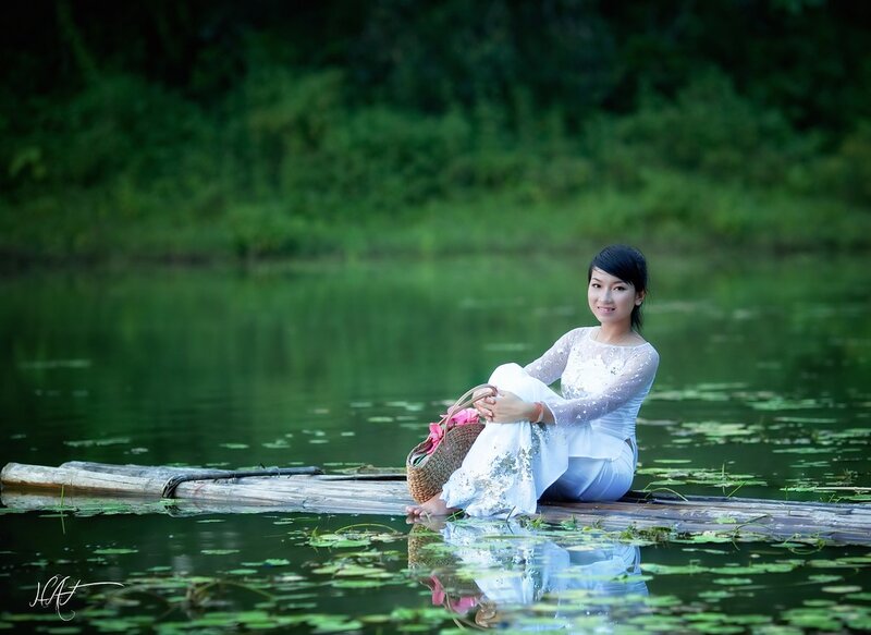 Woman in white on a bamboo raft