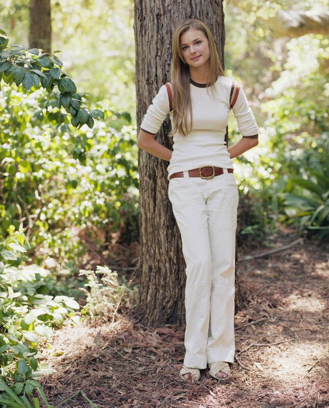Woman in white outfit by tree