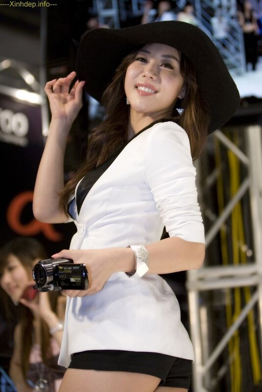 Woman in white outfit holding camera