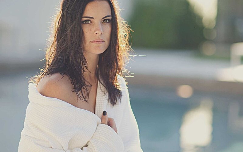woman in white robe by pool