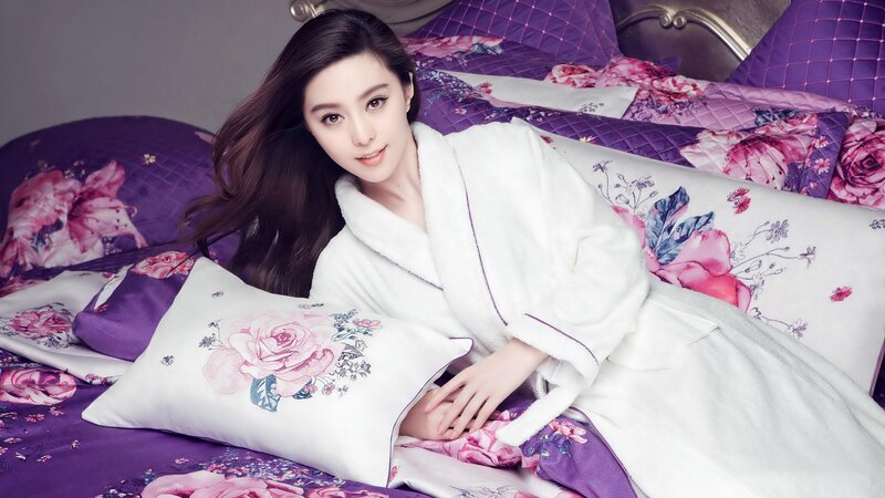 woman in white robe on bed