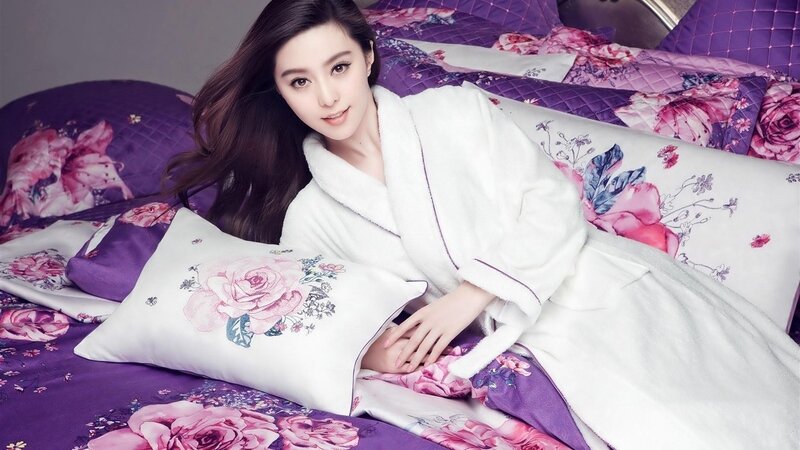 woman in white robe on floral bed