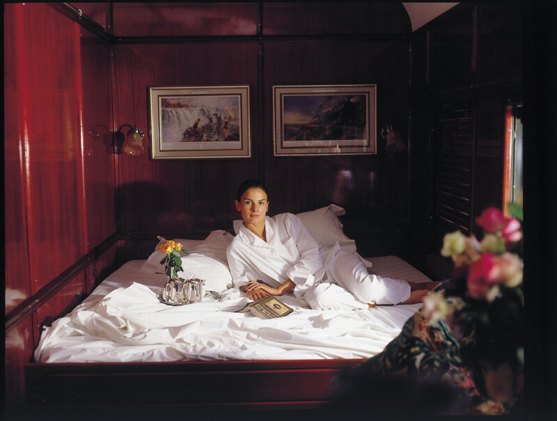 Woman in white robe on train bed