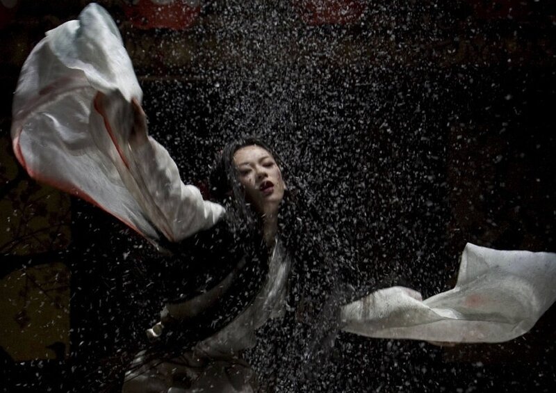woman in white robe under falling debris