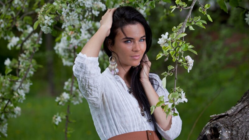 woman in white shirt by blossoming tree