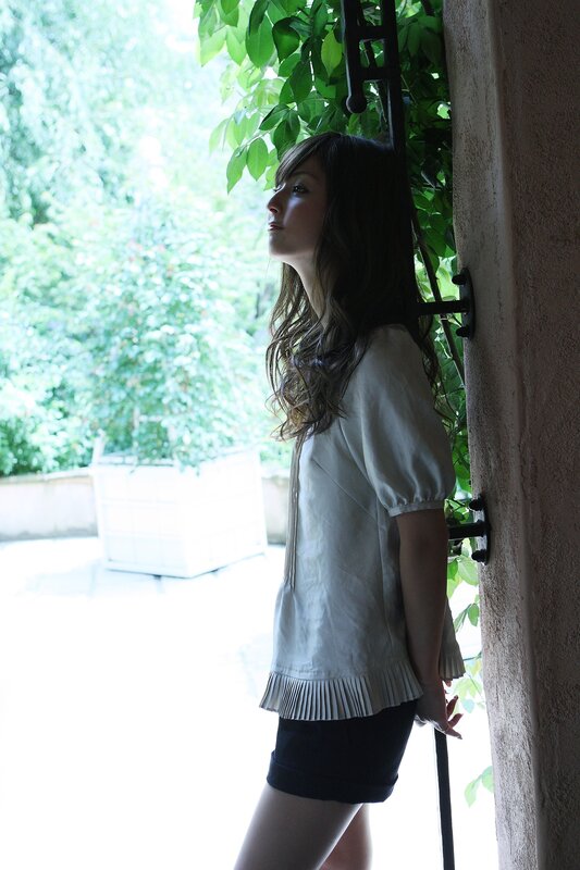 woman in white shirt by greenery