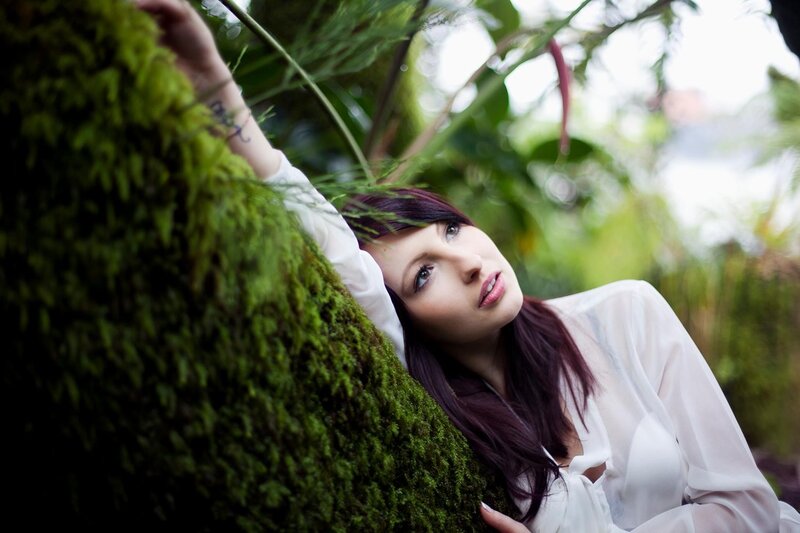 woman in white shirt by moss