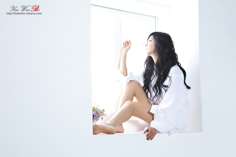 woman in white shirt by window