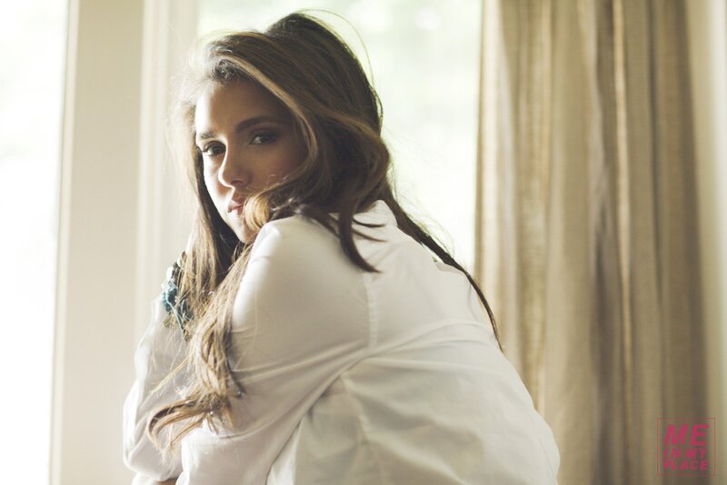 woman in white shirt by window