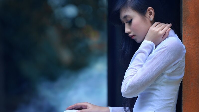 woman in white shirt by window