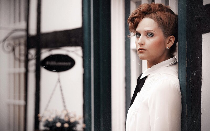woman in white shirt by window