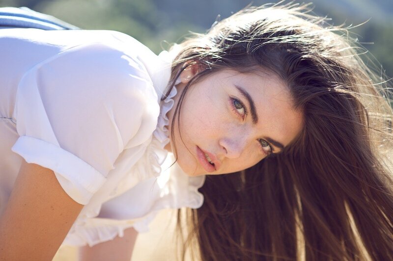 woman in white shirt looking at camera