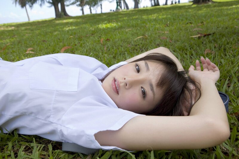 Woman in white shirt lying on grass