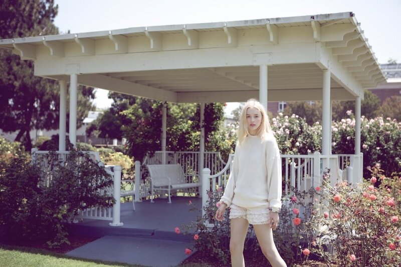 Woman in white sweater by gazebo