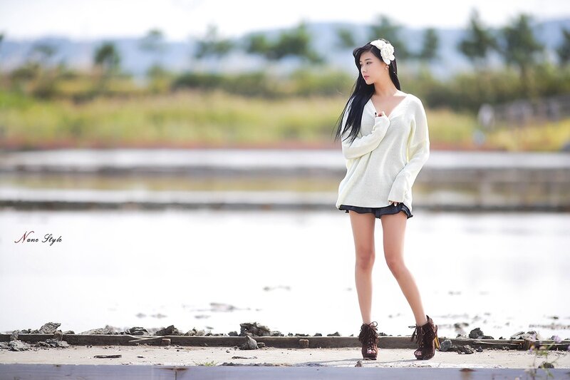 Woman in white sweater by water