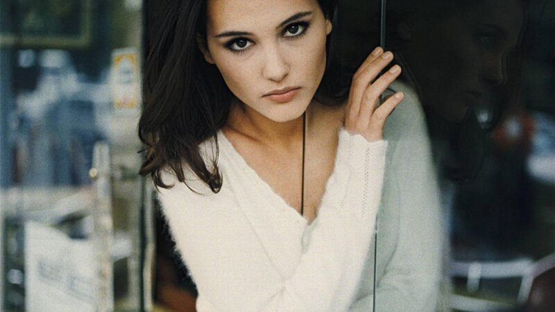woman in white sweater by window