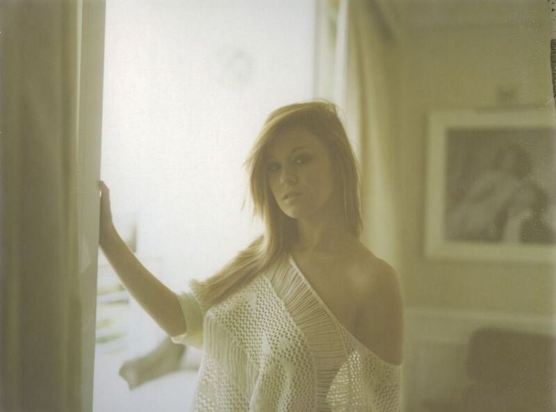 woman in white sweater by window