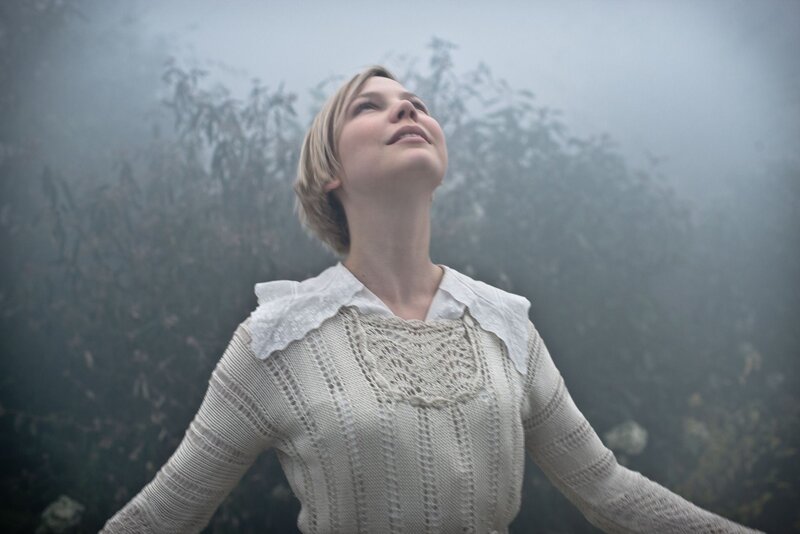 woman in white sweater looking up