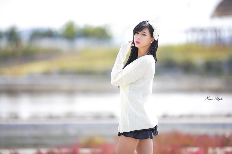 Woman in white sweater outdoors
