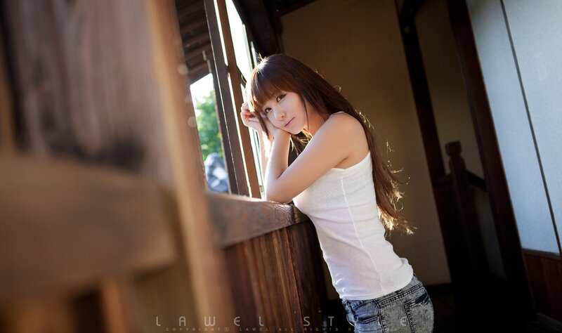 woman in white tank top by window