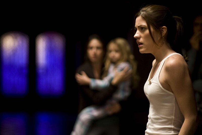 Woman in white tank top looking concerned